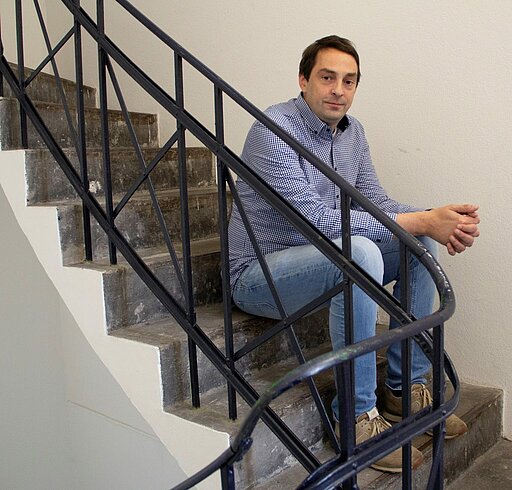 Lungenkrebs: Dr. Scheffler von der Lung Cancer Group Dr. Matthias Scheffler sitzt auf einer Treppe und schaut in die Kamera.